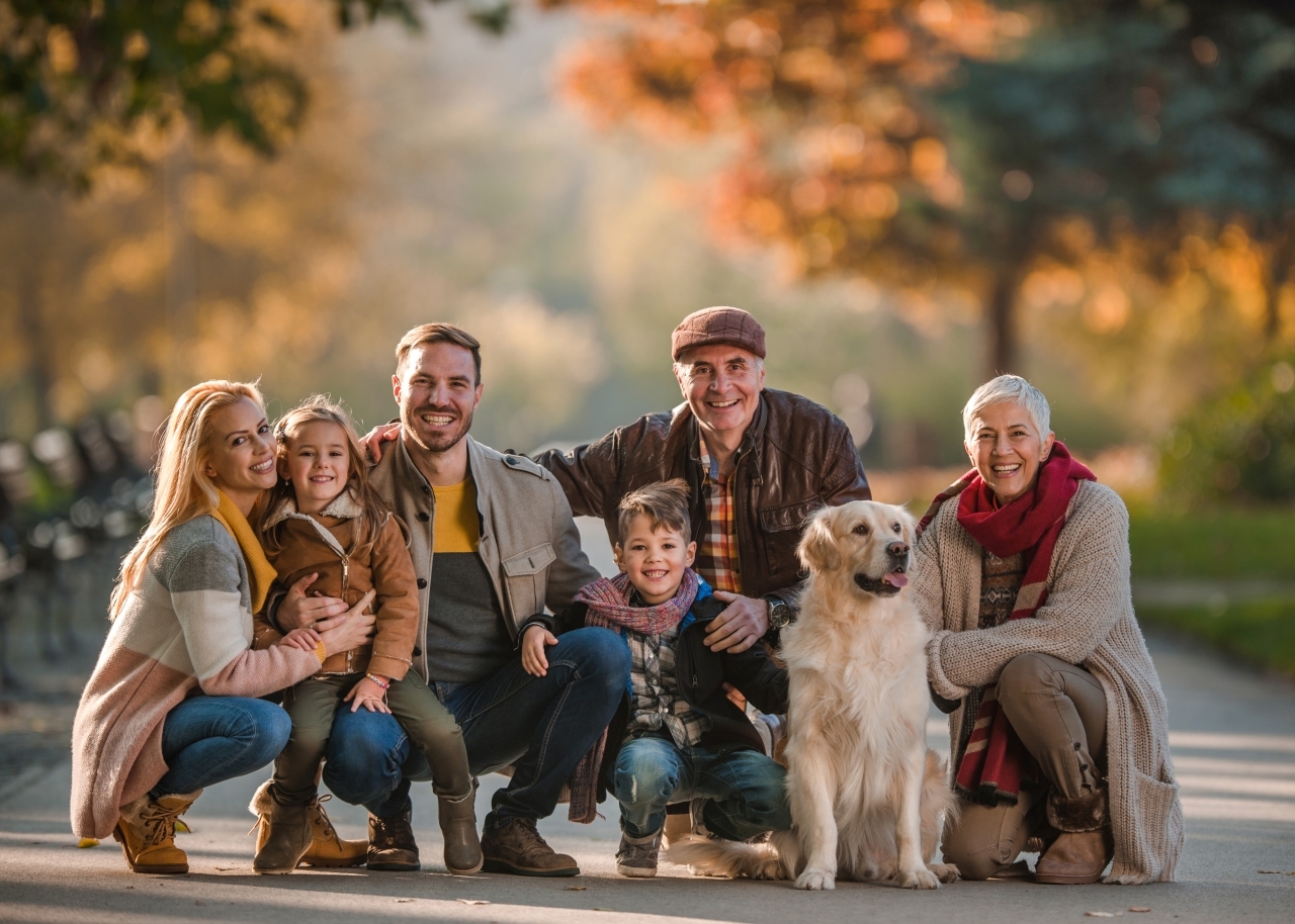 big family posing for fall photograph in park